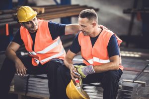 Construction worker supporting colleague